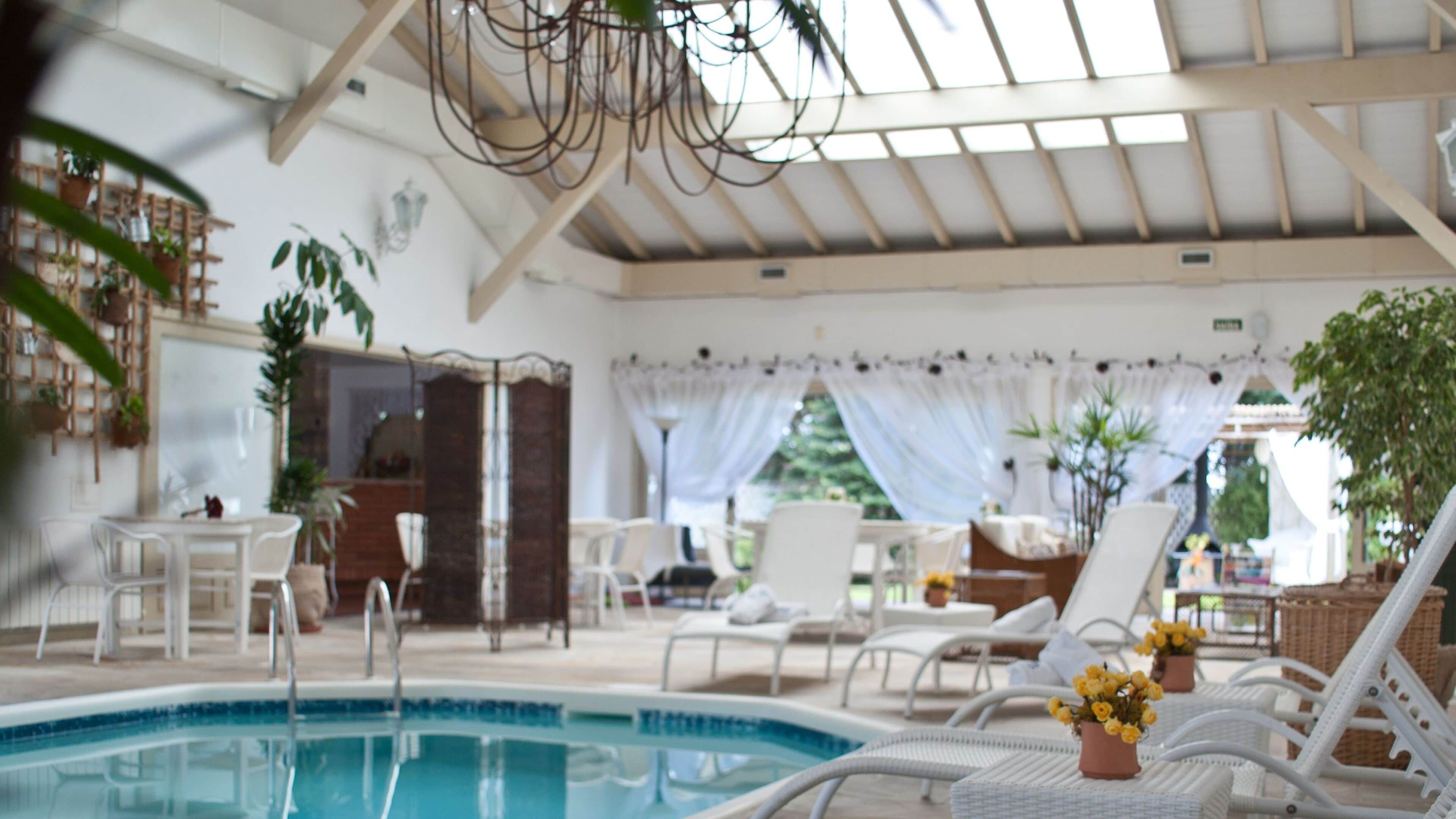 Una piscina techada, sillones reclinables de piscina