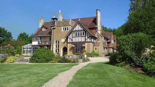 A large, historic house with a well-maintained lawn and a gravel path leading to the entrance. - Farnham House Hotel (Farnham)