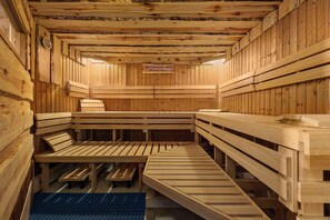 A sauna with wooden benches and benches, a blue mat, and a sign on the wall. - Good Morning + Halle - Leipzig (Kabelsketal)