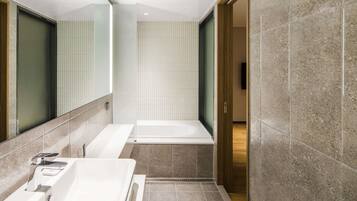 A modern bathroom with a bathtub, a shower, and a sink.