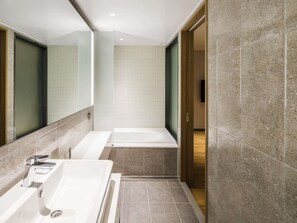 A modern bathroom with a bathtub, a shower, and a sink. - ibis Suwon Ambassador (Suwon)