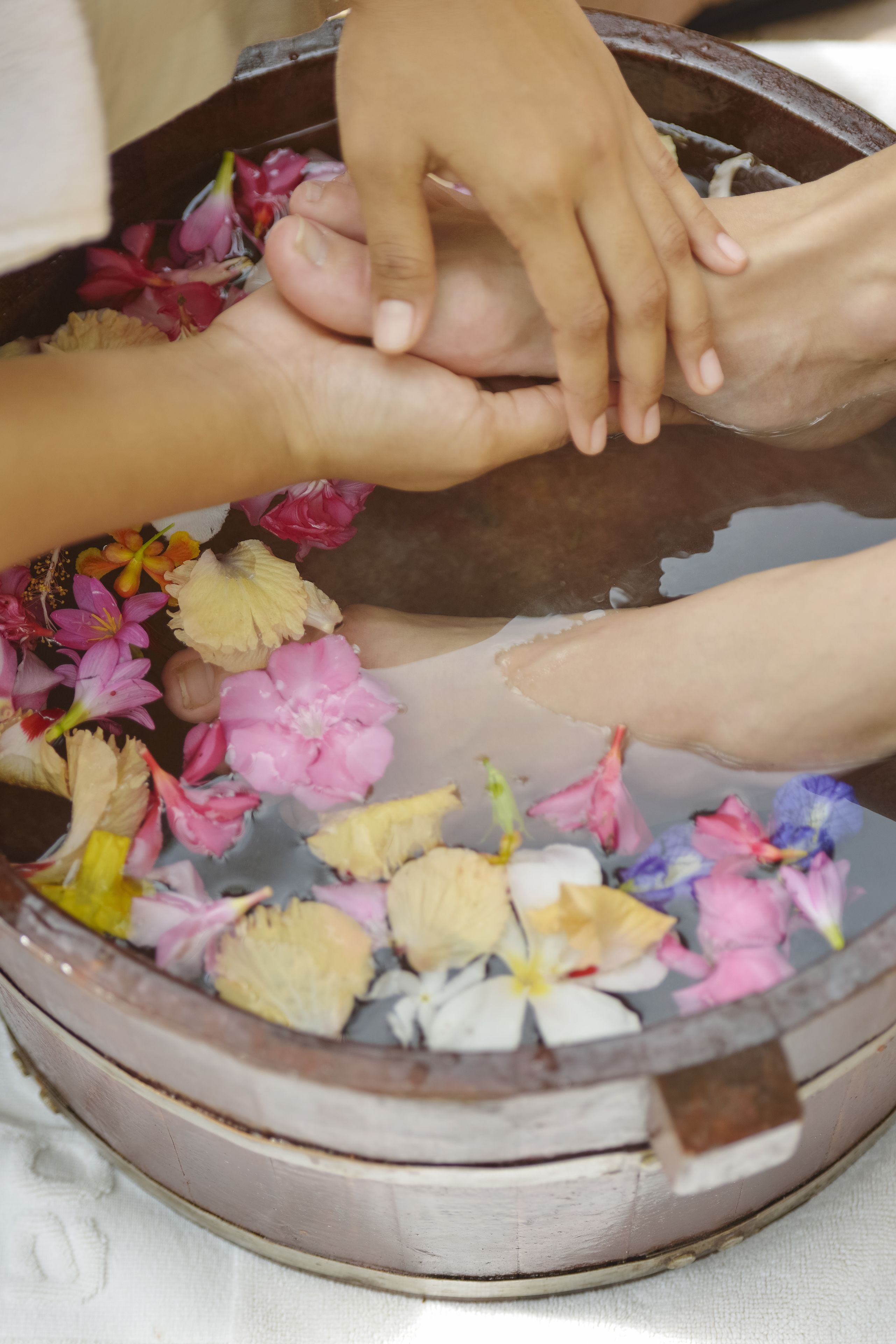 A wooden basin filled with water and flower petals.