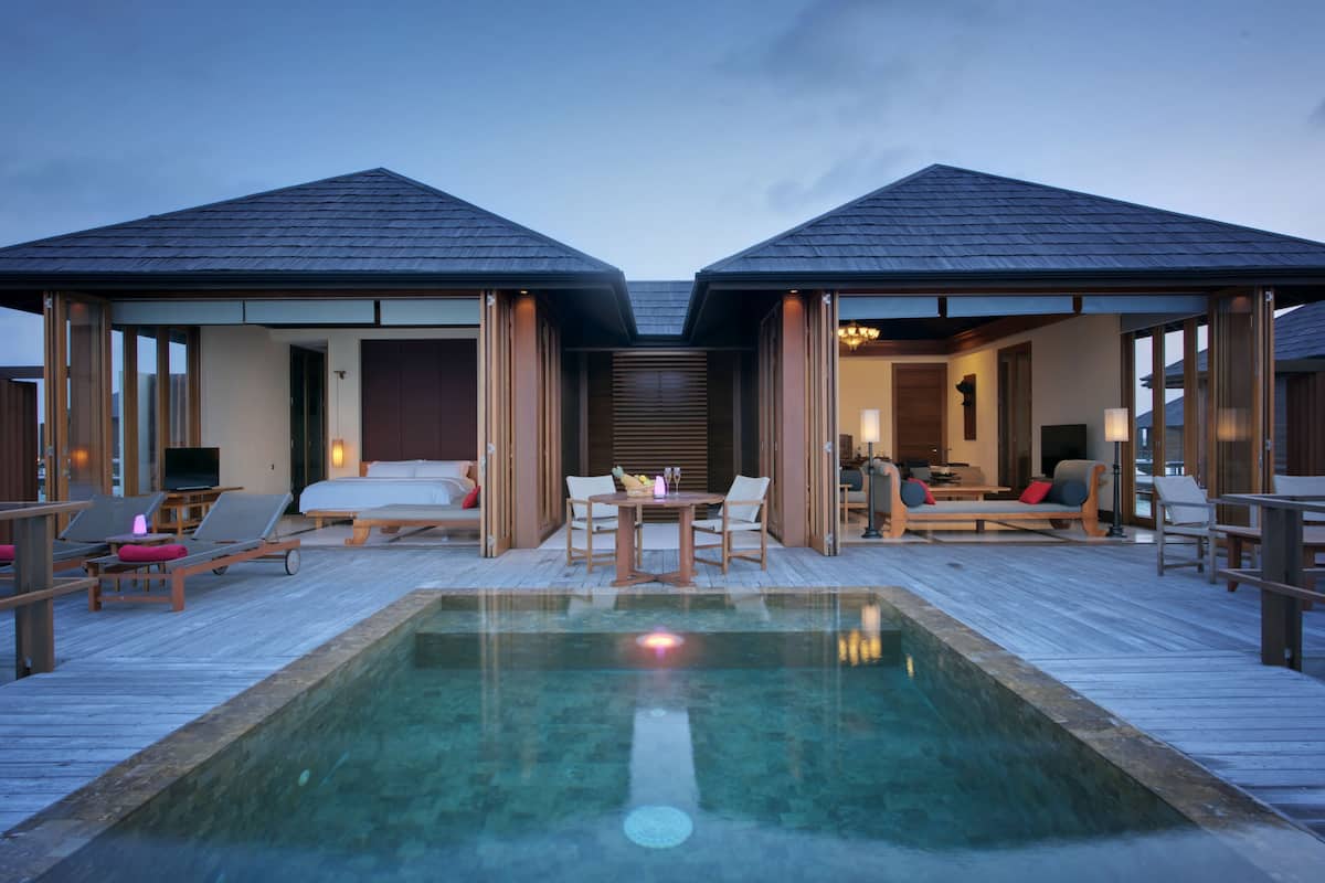 Un resort con piscina, dos habitaciones para huéspedes y un comedor.