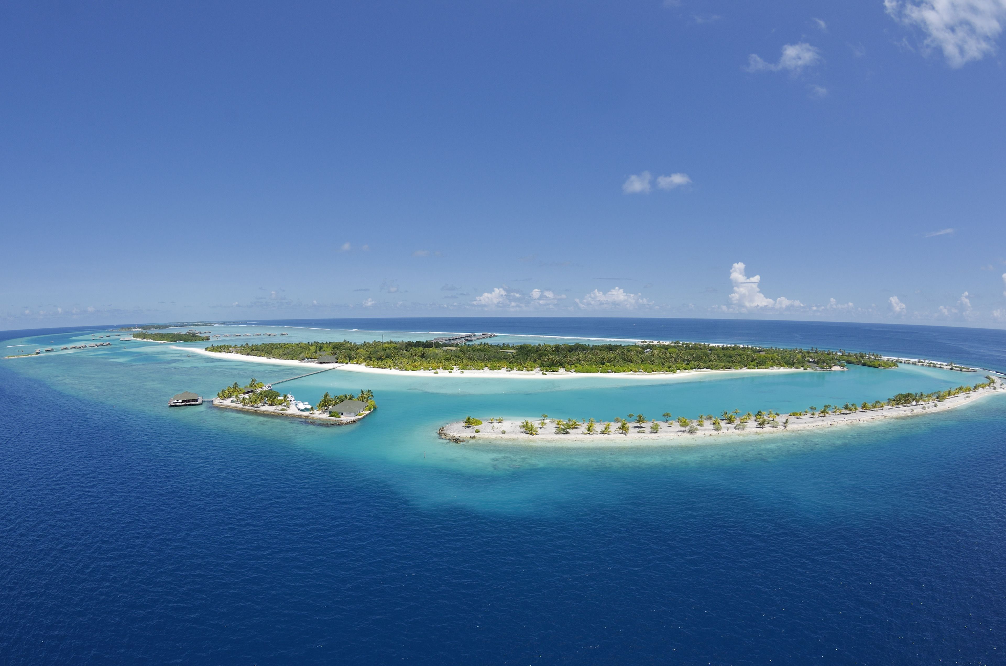 Vue aérienne d’une île tropicale aux eaux d’un bleu limpide et à la végétation luxuriante.