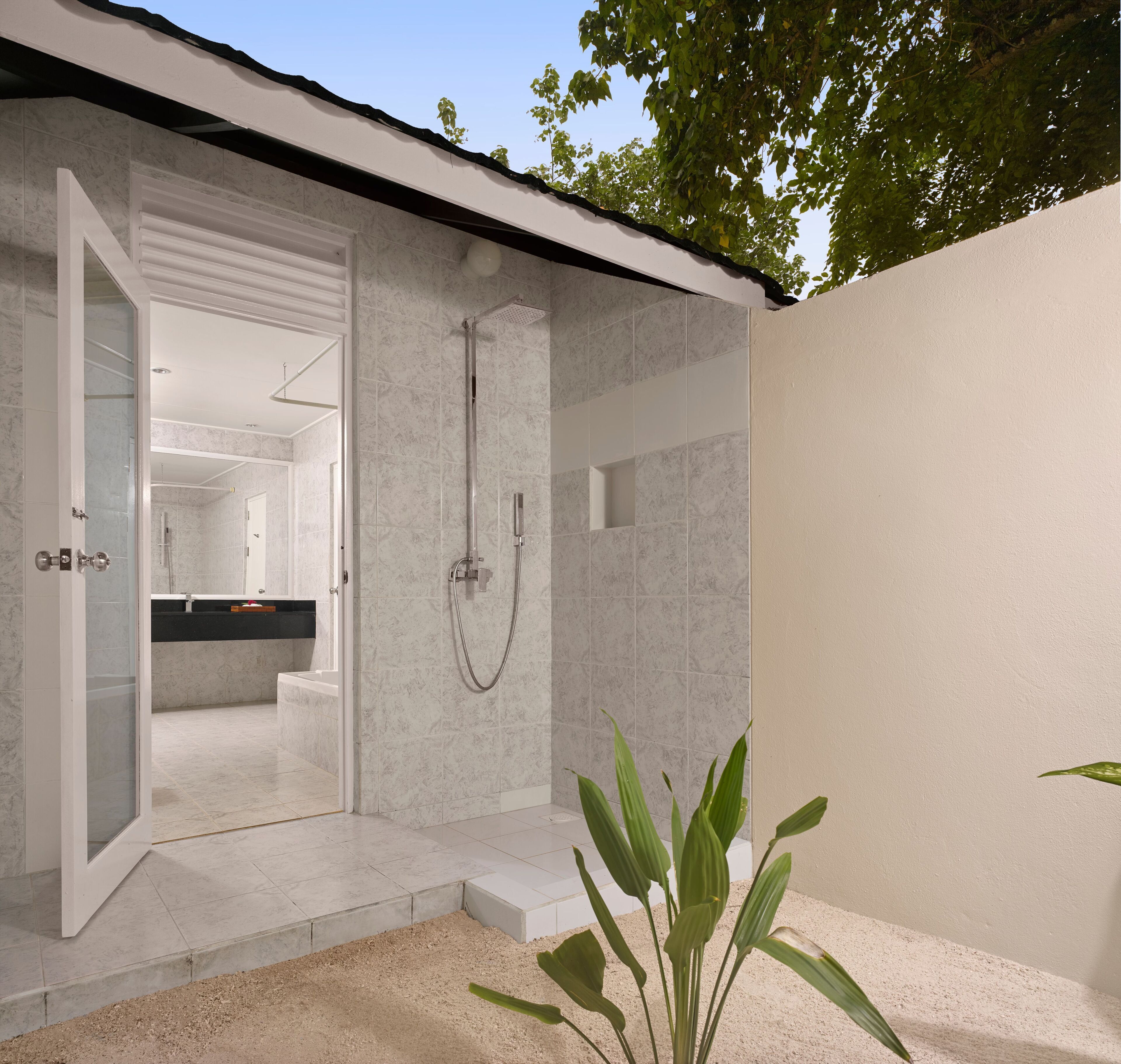 Ein modernes Badezimmer mit Glasdusche, Dusche und sichtbarer Waschtischfläche.