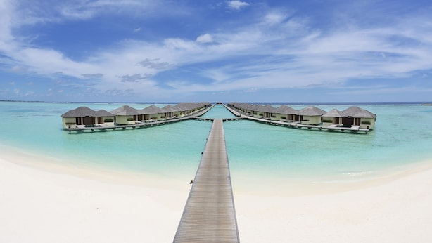 A long wooden pier leading to overwater bungalows with a clear view of the turquoise sea and white sand. - Villa Nautica Paradise Island Resort (Lankanfinolhu)