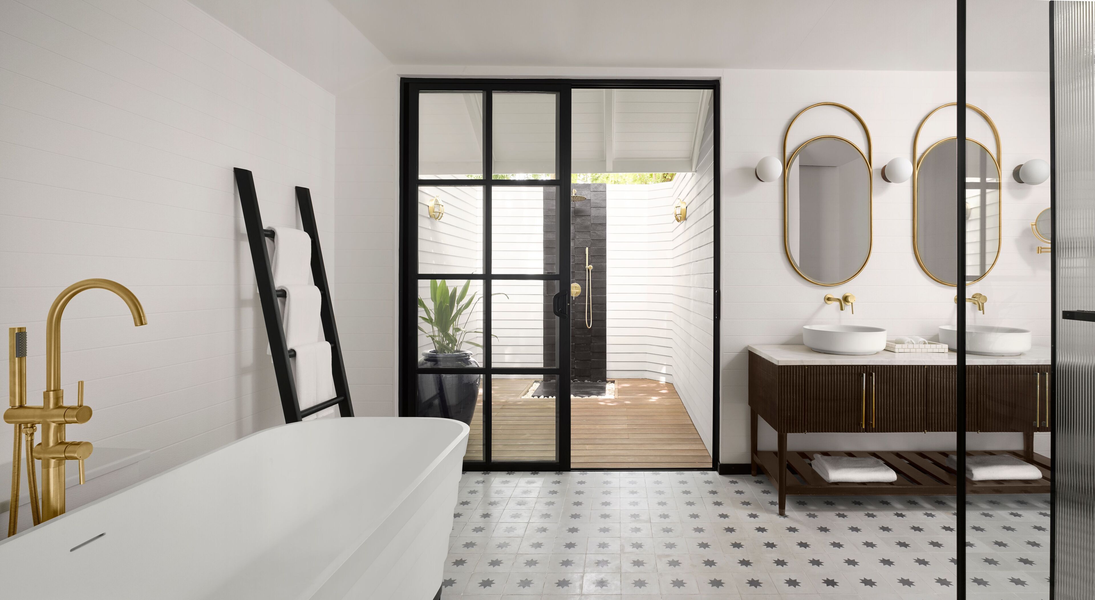 A modern bathroom with a freestanding bathtub, a vanity with two sinks, and a large mirror.