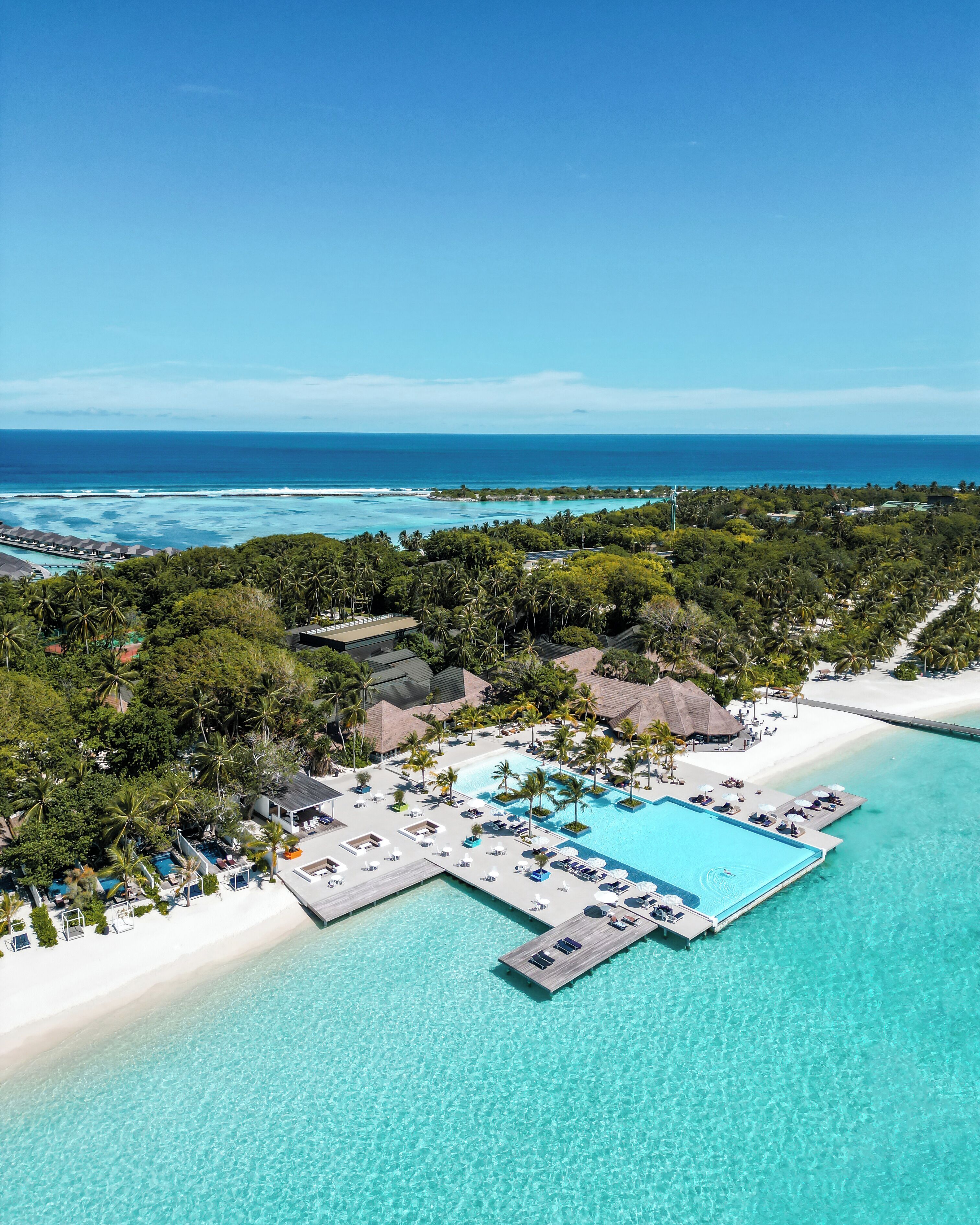 Een buitenzwembad, parasols bij het zwembad en ligstoelen