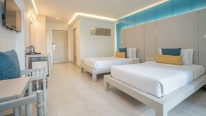 Een hotelkamer met een groot bed, twee kleinere bedden, een bureau en een televisie aan de muur.