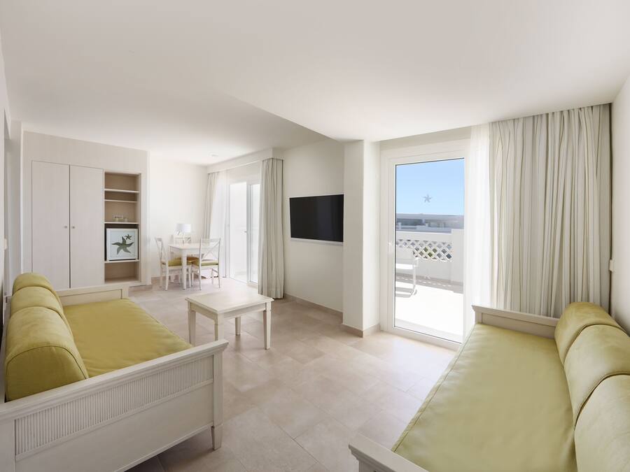 A spacious room with a bed, a desk, and a TV.