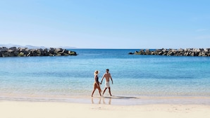 A beach with clear blue water and rocky breakwaters. - Iberostar Selection Lanzarote Park (Yaiza)
