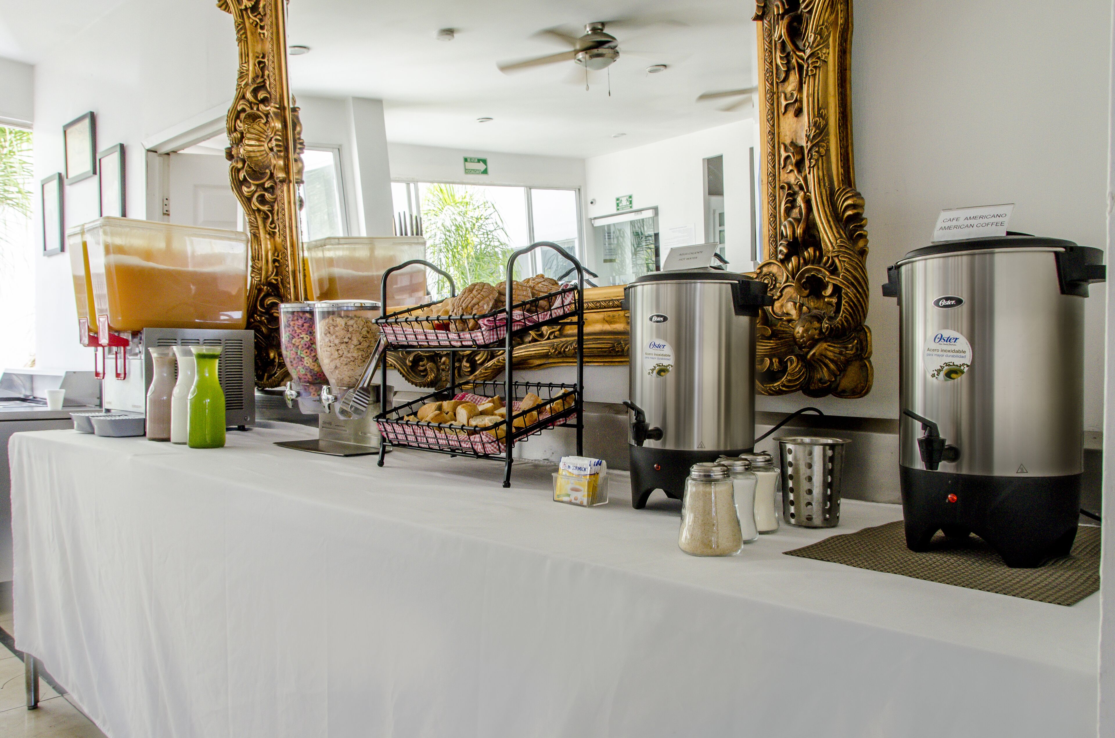 A breakfast buffet setup with various food items and beverages.