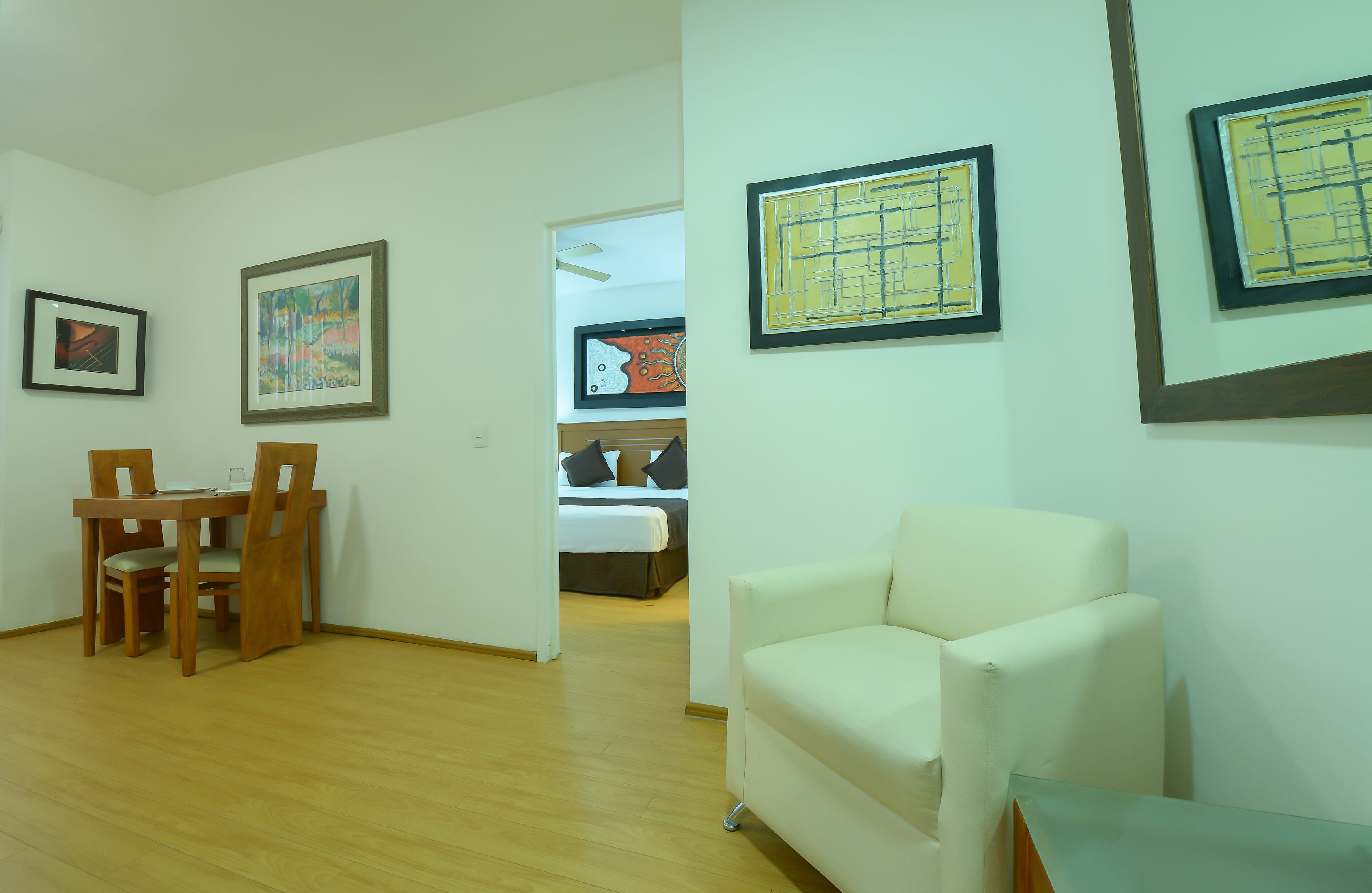 Ein Zimmer mit Esstisch, Stühlen, einer Couch und Kunstwerken an den Wänden.