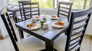 A dining table with plates of food, cups, and a bottle. - European Life Style Executive Suites & Gallery (Zapopan)