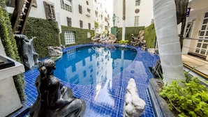 A swimming pool with statues and a fountain, surrounded by a white building with multiple windows and balconies. - European Life Style Executive Suites & Gallery (Zapopan)