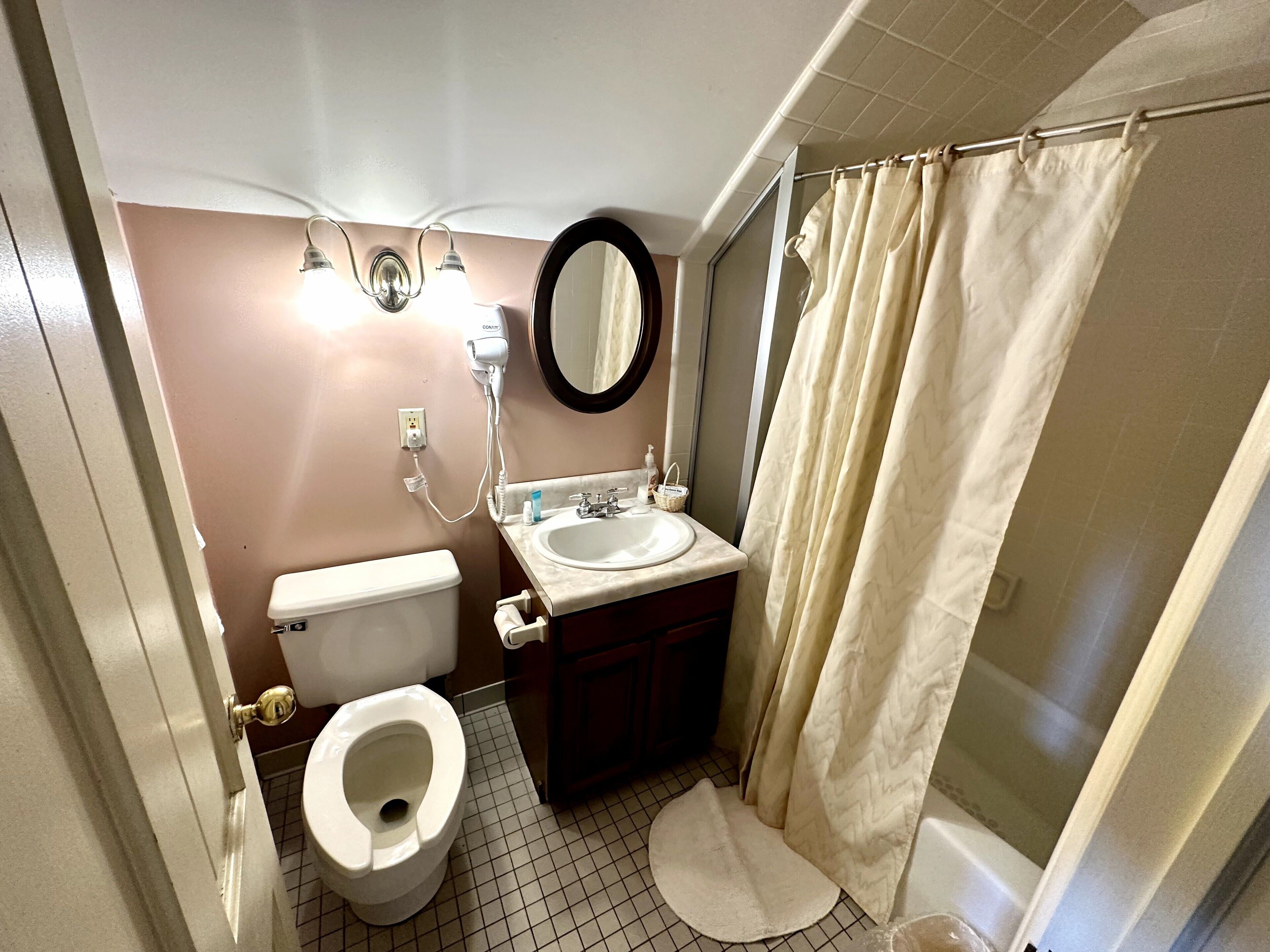 A bathroom with a toilet, sink, and shower.