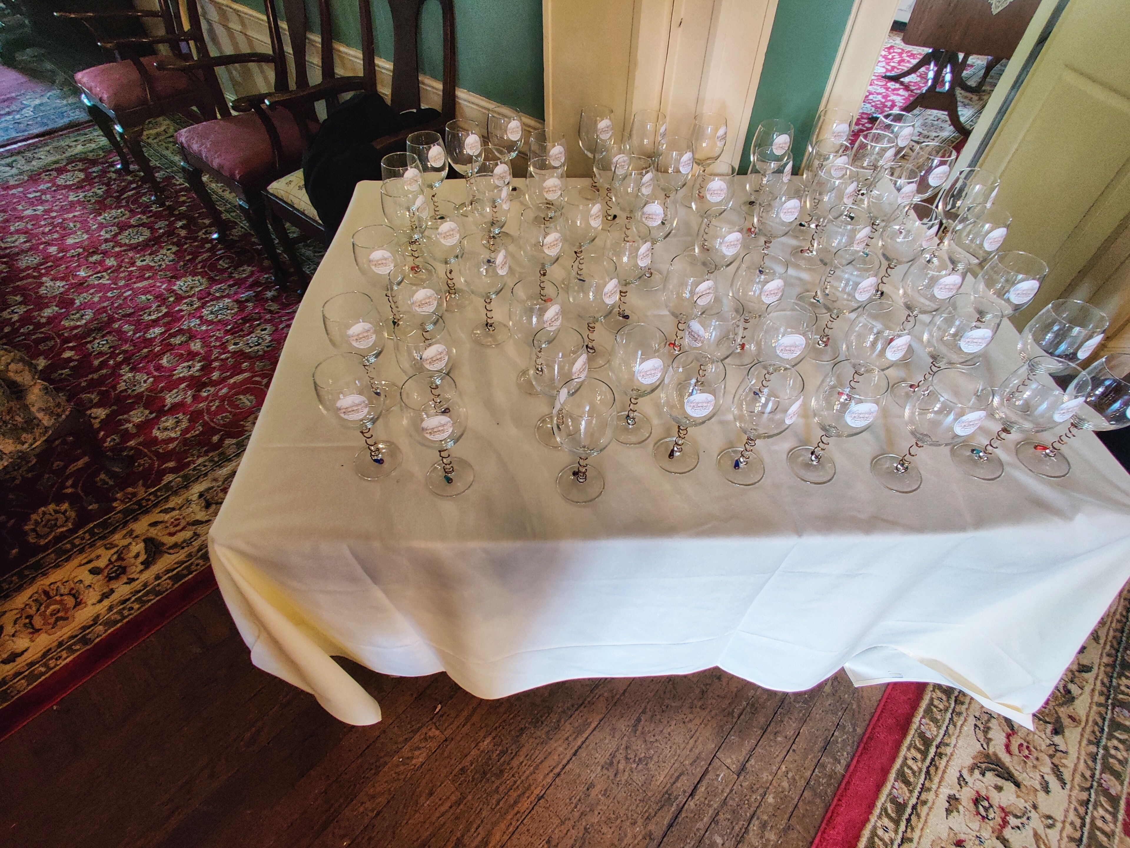 A table covered with numerous wine glasses arranged neatly.
