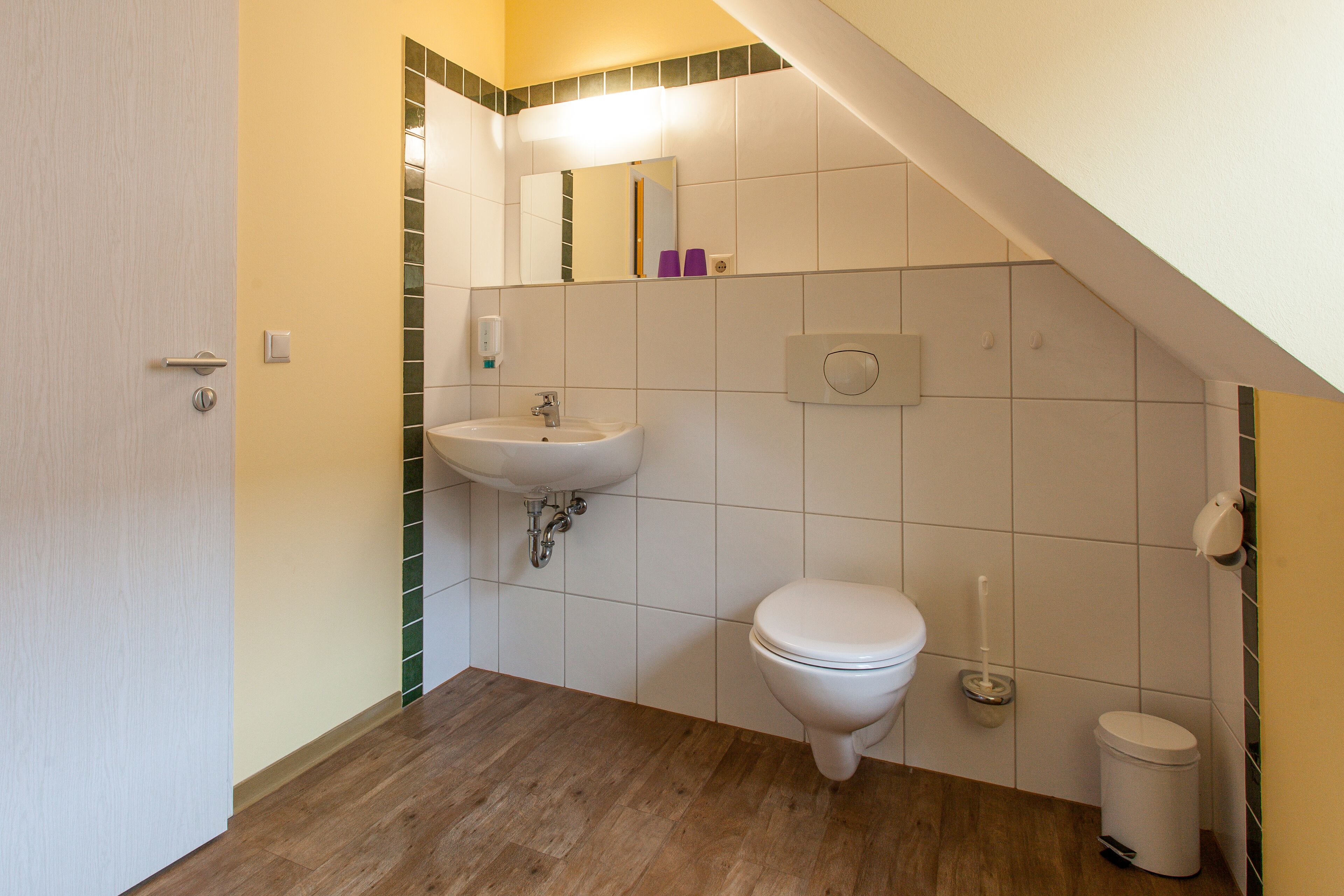 Ein Badezimmer mit Waschbecken, Toilette und Spiegel.