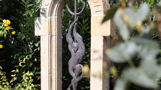 A stone archway with the inscription "MOLLE 5A" and a decorative metal figure.