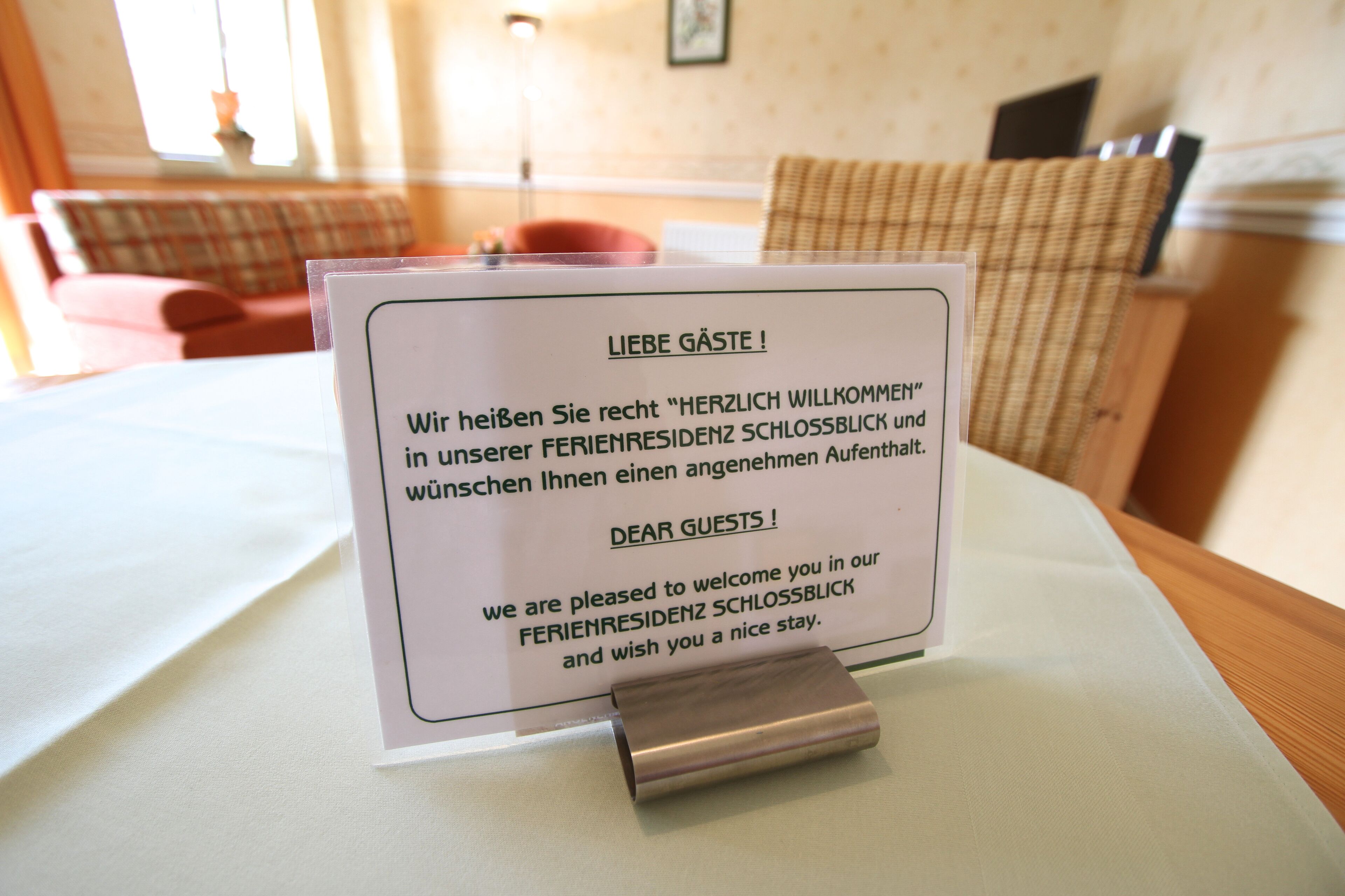 A welcome sign in a hotel room with a message in German.