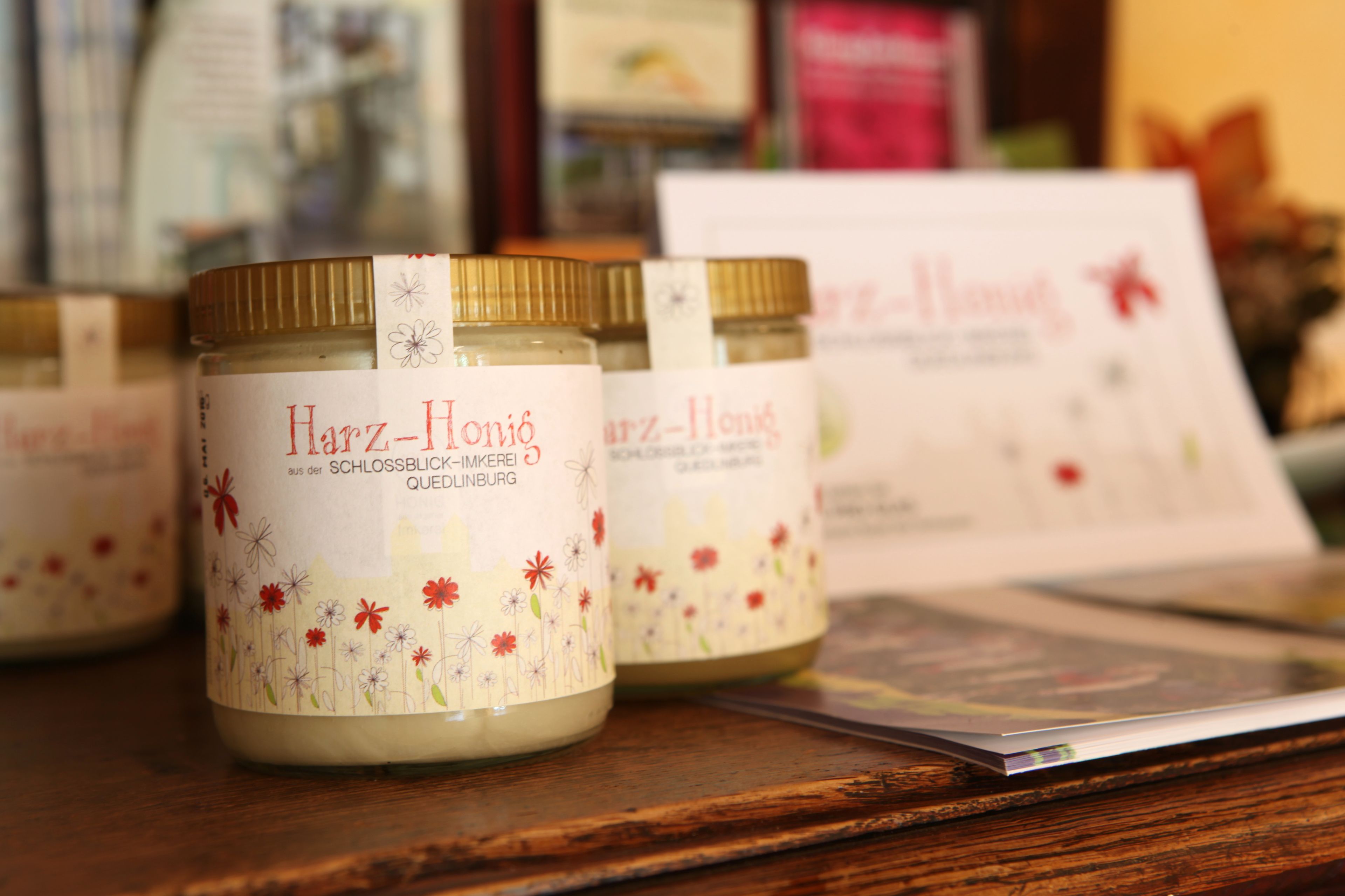 Jars of Harz-Honig on a wooden surface with a blurred background.