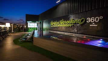Een modern gebouw met een neonbord waarop 'Despina Barcelona 360º' en 'Heineken' staat.