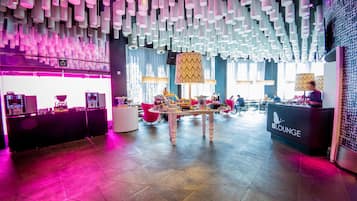 A modern lounge area with a central table, seating, and a 'BLOUNGE' sign.