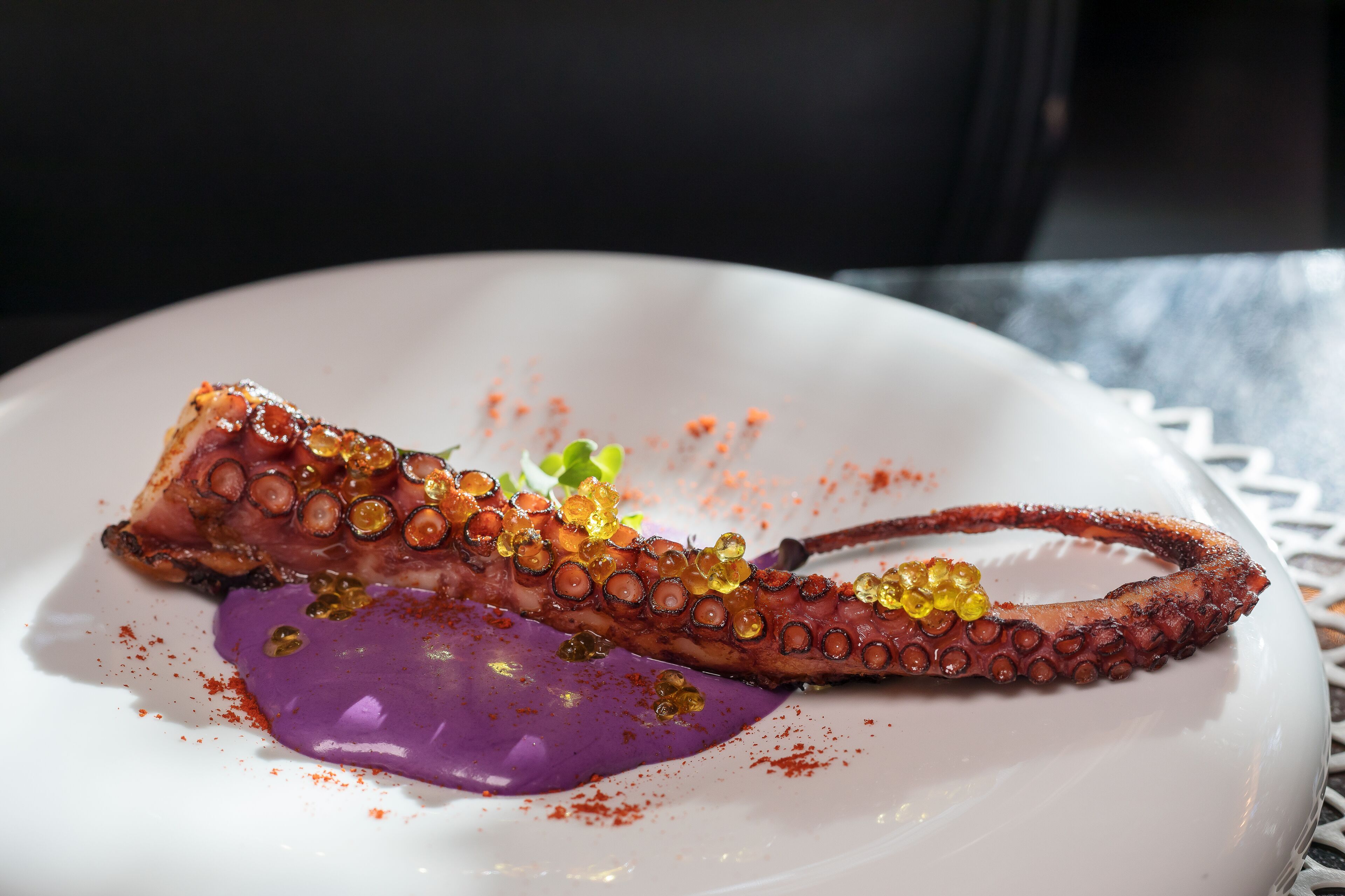 Un plato de pulpo con salsa morada.