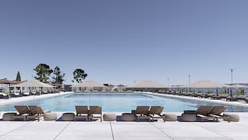 Una piscina al aire libre de temporada, sombrillas