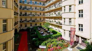 A multi-story hotel with a central courtyard, outdoor seating, and a red carpet leading to the entrance. - Hotel & Apartments Zarenhof Berlin Prenzlauer Berg (Berlin)