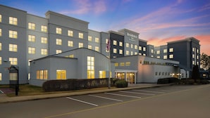 A multi-story hotel with a modern design, featuring a prominent entrance and a parking lot. - Residence Inn Newport News Airport (Newport News)