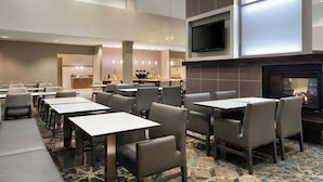 A hotel lobby with multiple seating areas, a television, and a fireplace. - Residence Inn Newport News Airport (Newport News)