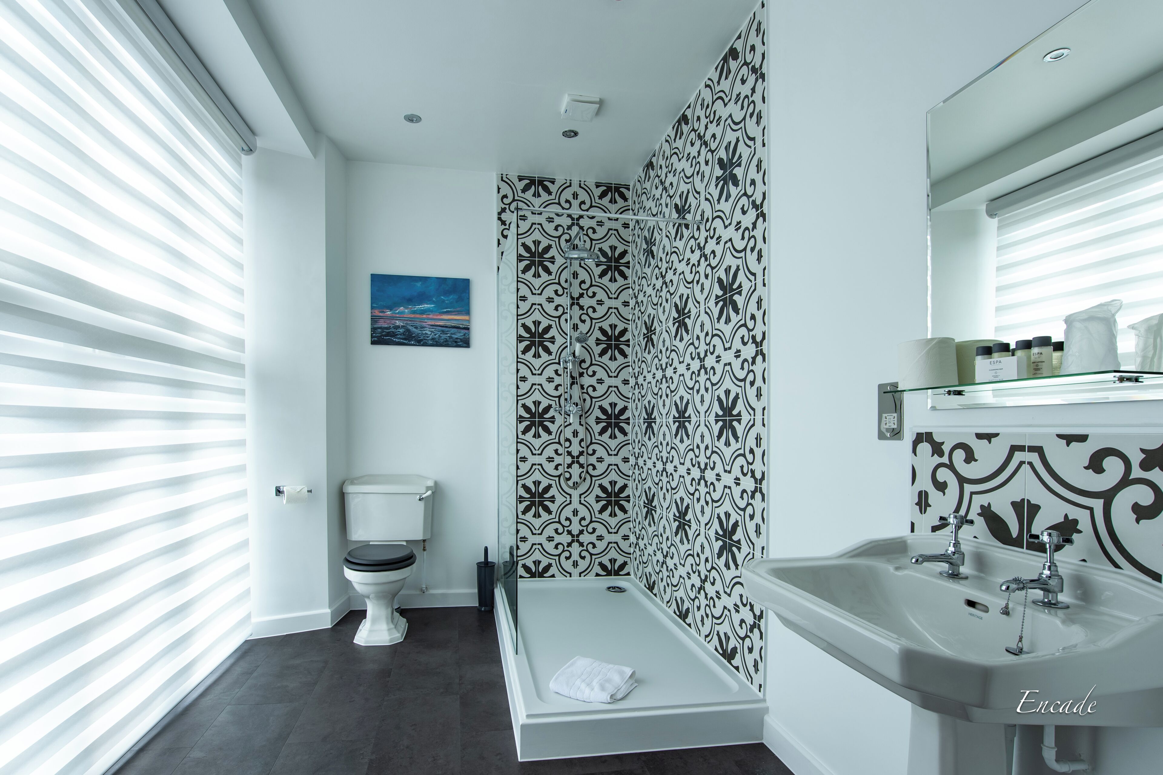 A modern bathroom with a toilet, shower, and sink.