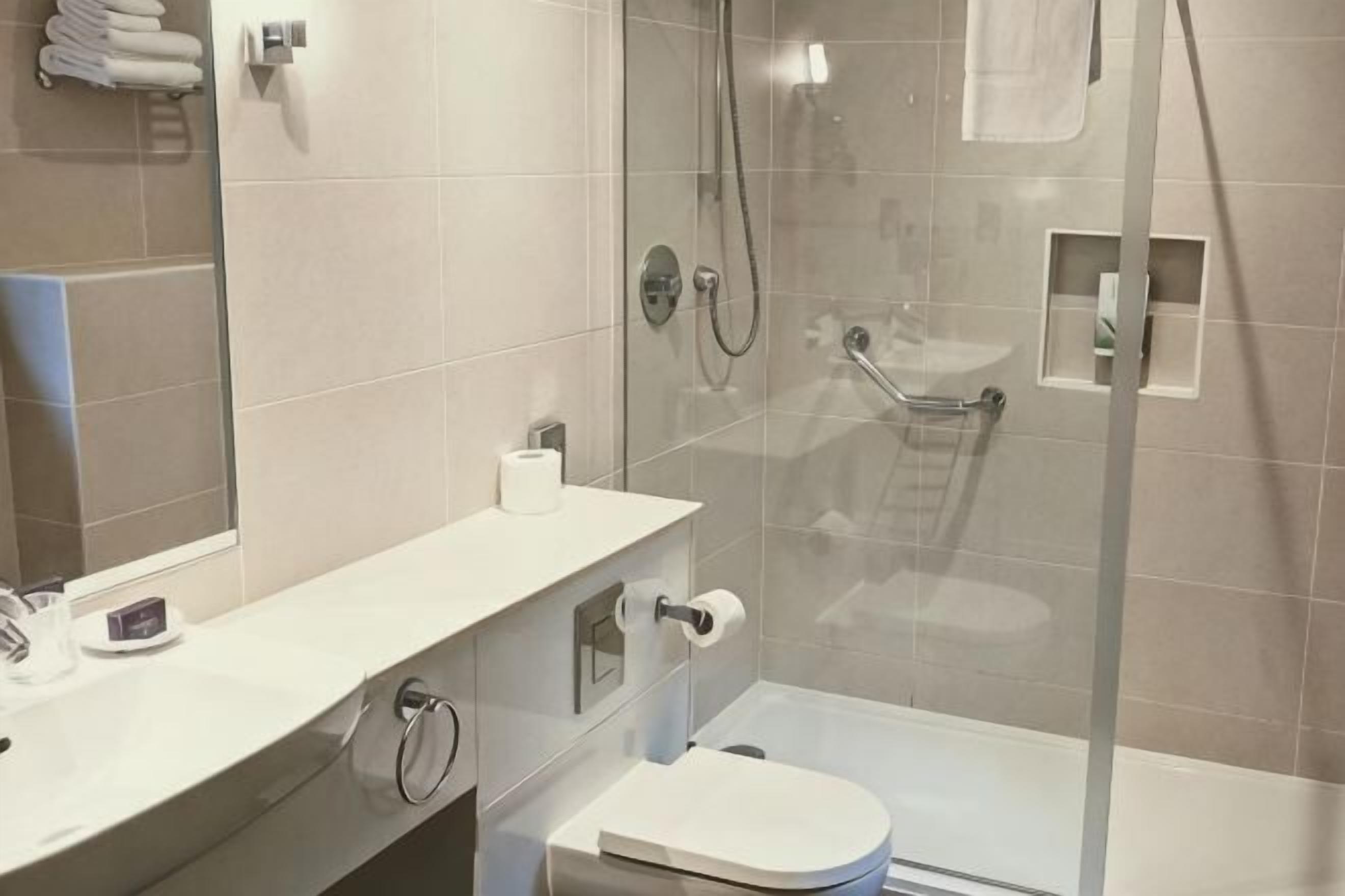 A modern bathroom with a toilet, sink, and shower.
