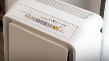 A white air purifier with a control panel featuring multiple buttons and a digital display.