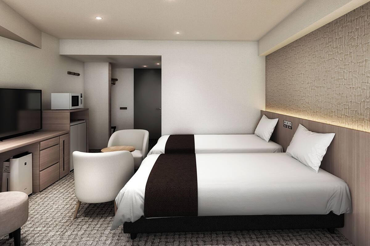 Une chambre d’hôtel équipée d’un lit, d’un bureau avec une télévision, d’une chaise et d’un four à micro-ondes.