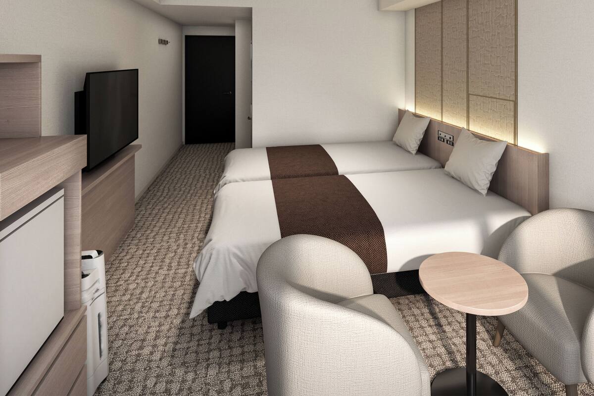 Une chambre d’hôtel avec un lit, une télévision, un bureau et une chaise.