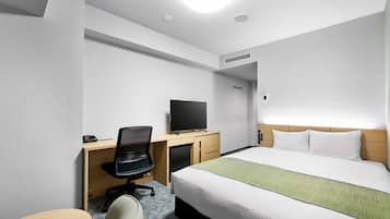 A hotel room with a bed, a desk with a chair, a television, and a small table.
