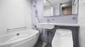 A modern bathroom with a freestanding bathtub, a pedestal sink, and a toilet.