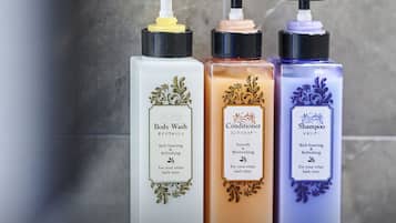Three bottles of body wash, conditioner, and shampoo on a shelf.