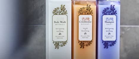 Three bottles of body wash, conditioner, and shampoo on a shelf.