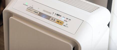 A white air purifier with a control panel featuring multiple buttons and a digital display.