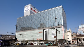 Un hotel moderno con fachada de vidrio, varios letreros y una entrada destacada.