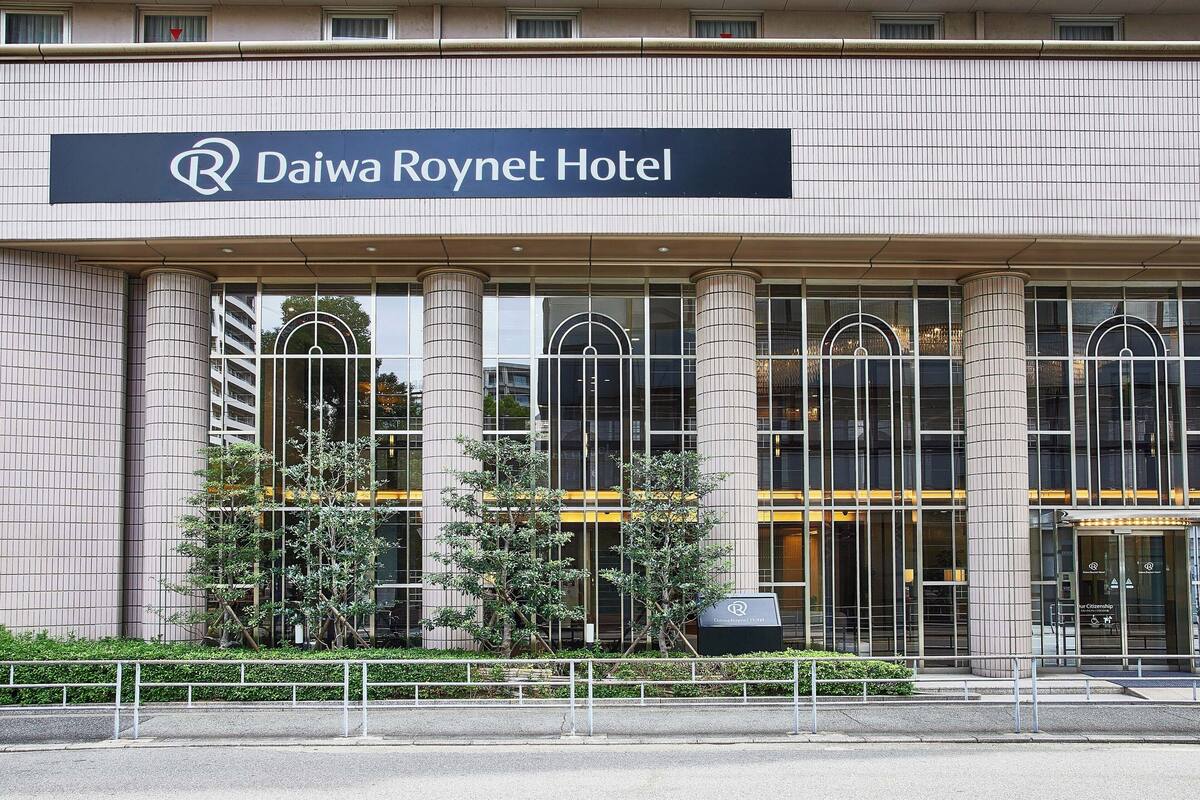 Exterior del hotel Daiwa Roynet, con un letrero grande, amplias ventanas y un diseño arquitectónico moderno.