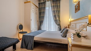 Una habitación de hotel con una cama, un escritorio, una silla y un armario.