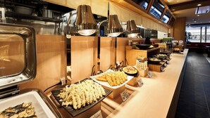 Un espace buffet proposant une variété de plats, notamment des brochettes et un coin grillades.
