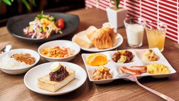 Una mesa con diversos platos, incluyendo arroz, un sándwich y una porción de pastel.