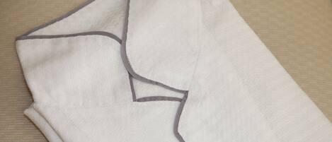 A neatly folded white shirt with a gray collar and a gray trim on the edges.
