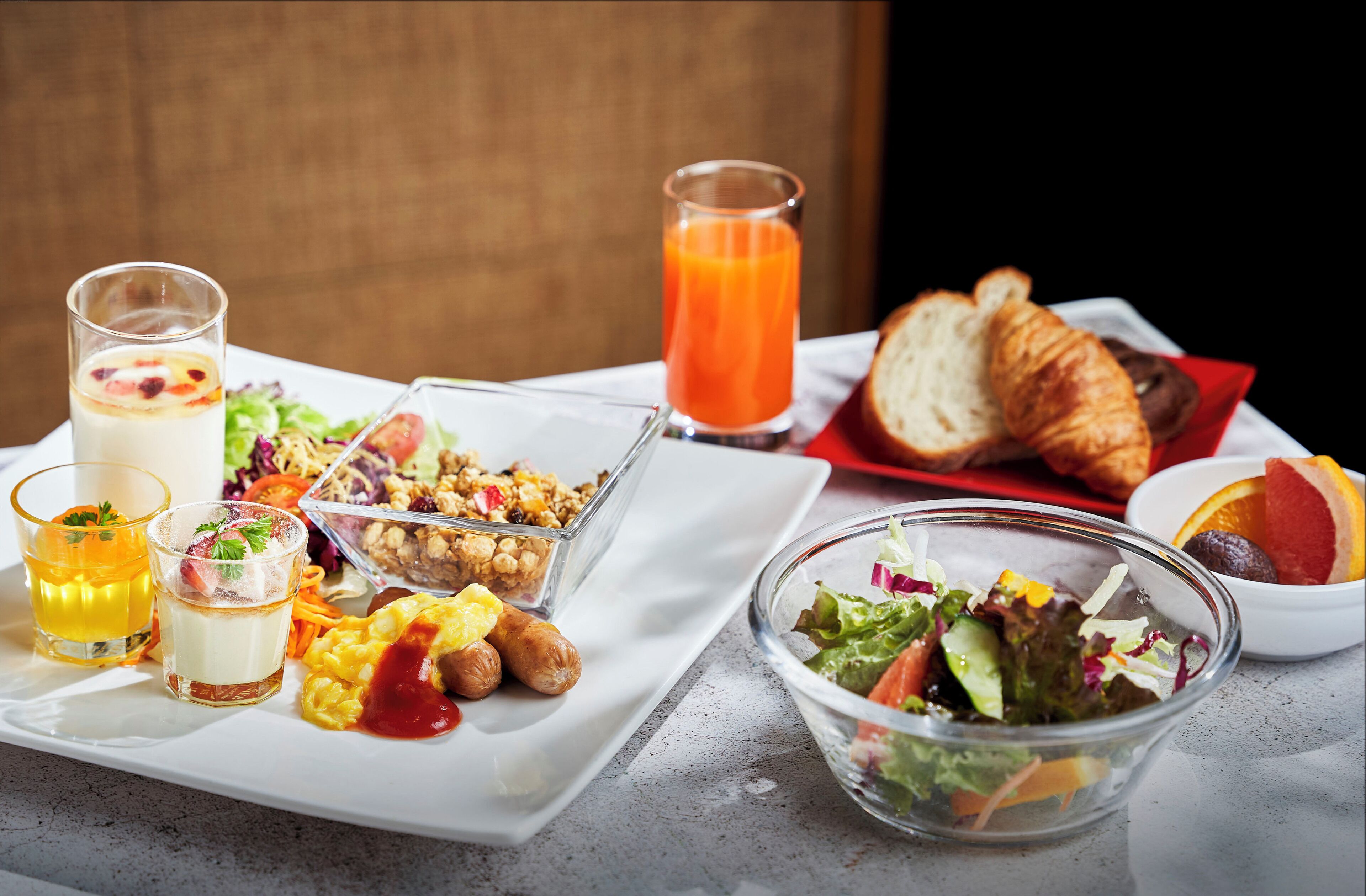 A breakfast setting with various dishes and drinks on a table.