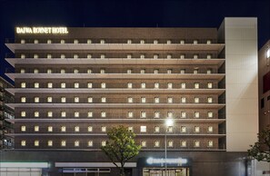 Un hôtel à plusieurs étages, reconnaissable à son enseigne bien visible indiquant « DAIWA ROYNET HOTEL ».